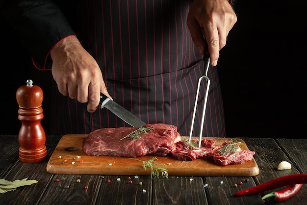 The chef prepares veal with his hands in the kitchen Menu idea for a restaurant or hotel