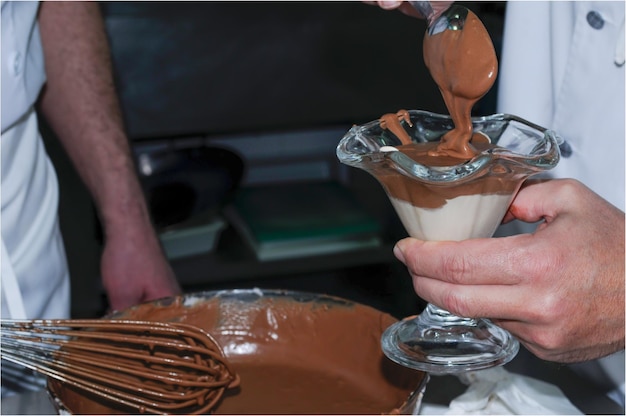 Chef preparing chocolate mousse in a glass cup