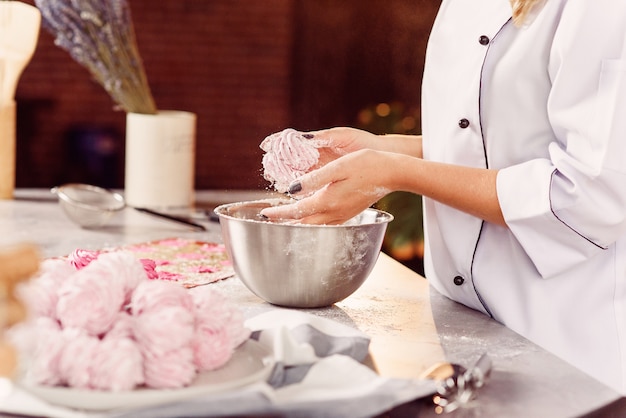 Chef preparing delicate homemade marshmallows with her hands. The concept of home cooking.