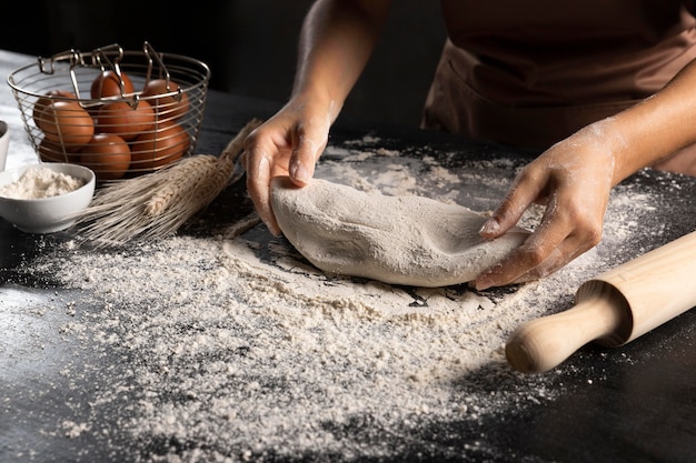 Chef preparing dough with rolling pin and flour