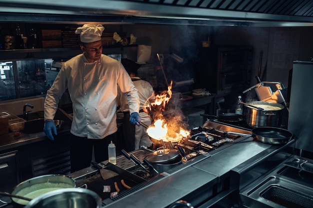 Chef preparing a meal using fire in the professional kitchen