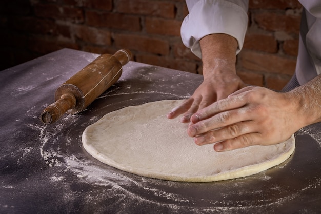 Chef preparing pizza dough in the kitchen