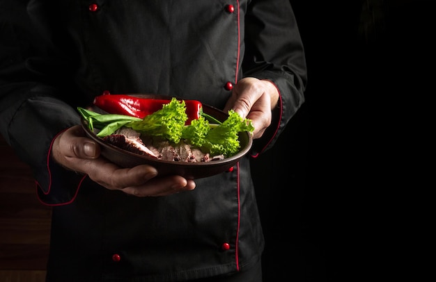 The chef presents his dish on a plate of sliced baked steak and vegetables