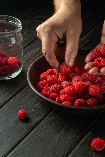 The chef sorts fresh raspberries before preparing a cold drink in the kitchen