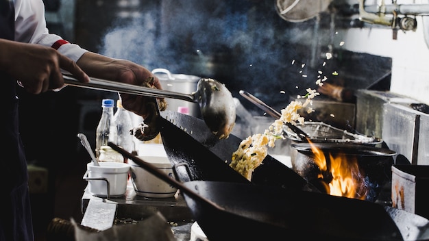 Chef stir fry cooking at wok