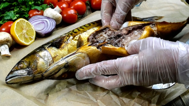 Chef take out guts from smoked mackerel before serving Next cherry tomatoes onions and parsley