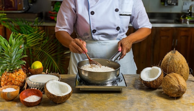 Photo a chef in a tropical kitchen preparing a variety of coconutbased dishes