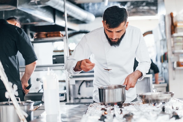 Chef in white uniform cooking food at kitchen Busy day at work