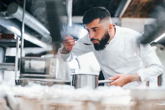 Chef in white uniform cooking food at kitchen Busy day at work