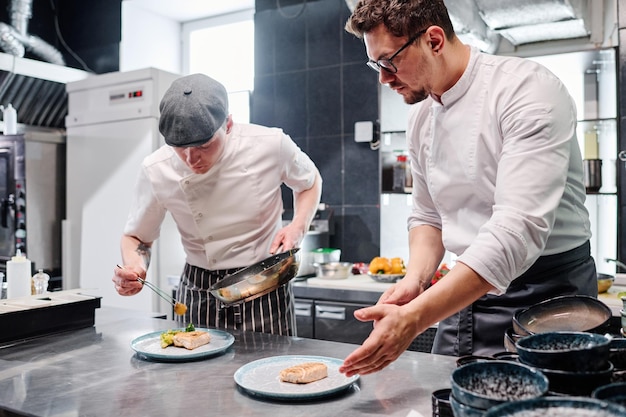 Chef with assistant putting dish on plate