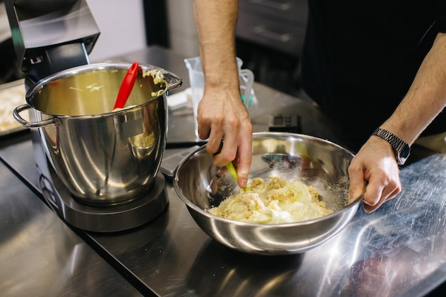 The chef works in the kitchen The process of making dough for macaroons