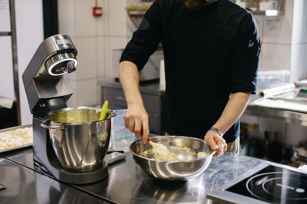 The chef works in the kitchen The process of making dough for macaroons