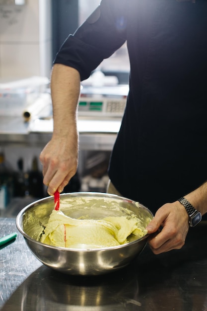 The chef works in the kitchen The process of making dough for macaroons