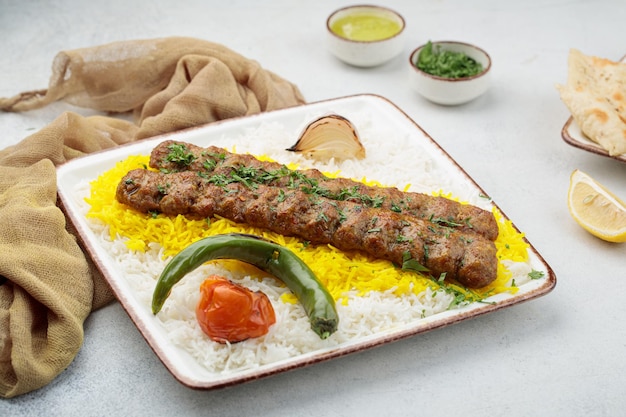 Chelo or Chelow Kabab with rice tomato and lime served in dish isolated on table top view of arabian food