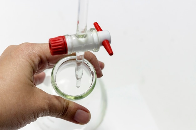 Chemical laboratory; Scientist hand titration with burette and erlenmeyer flask