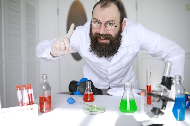 Chemist crazy. A mad scientist conducts experiments in a scientific laboratory. Performs research using a microscope.