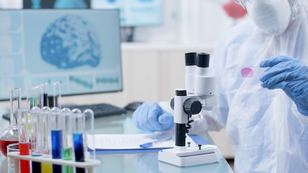 Chemist researcher holding medical slide analyzing dna blood sample writing medical expertise. Scientist doctor working at coronavirus vaccine during chemistry experiment in laboratory