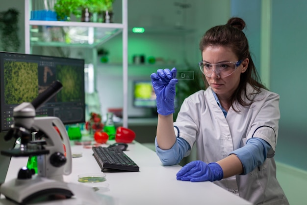 Photo chemist scientist looking at green leaf sample checking genetic mutation for biological experiment