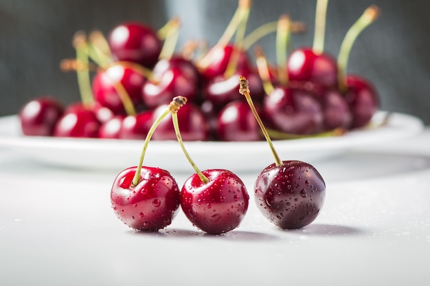 Cherries on a wooden table with water drops macro background