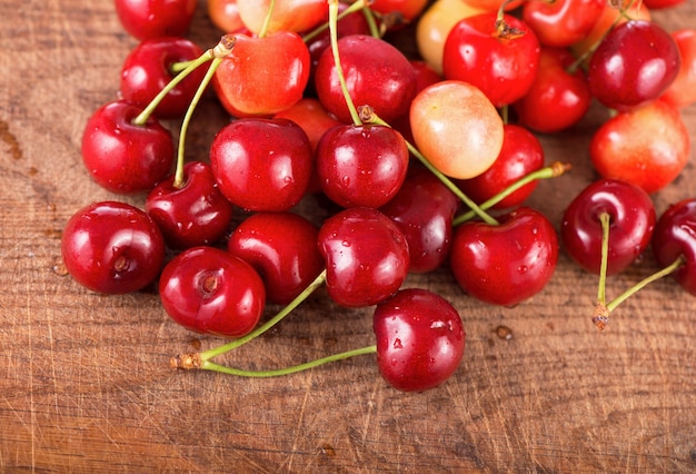 Cherries on wooden table with water drops macro surface