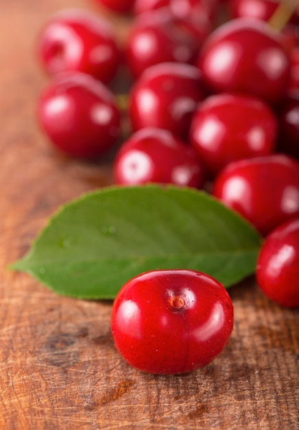 Cherries on wooden table with water drops macro surface