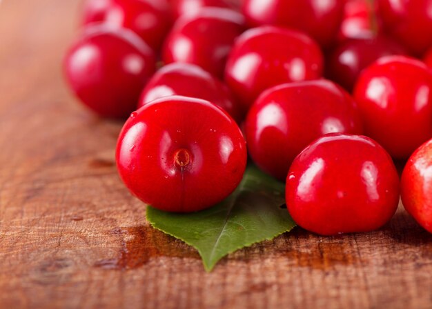 Cherries on wooden table with water drops macro surface