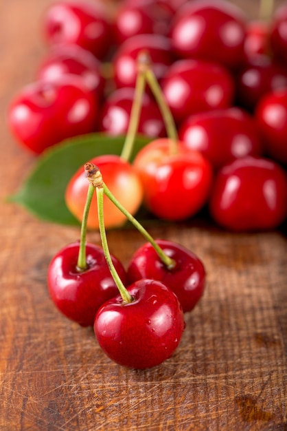 Cherries on wooden table with water drops macro surface