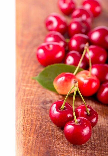 Cherries on wooden table with water drops macro surface