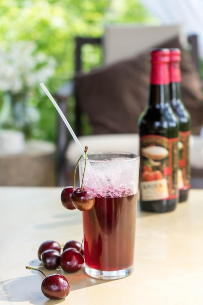 Cherry craft beer in a glass on a wooden table close up