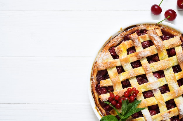 Cherry pie on a white wooden with place for text.