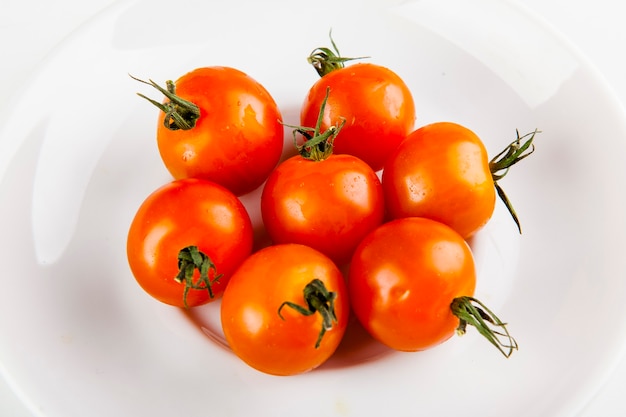 cherry tomatoes for adding to pizza on a white plate