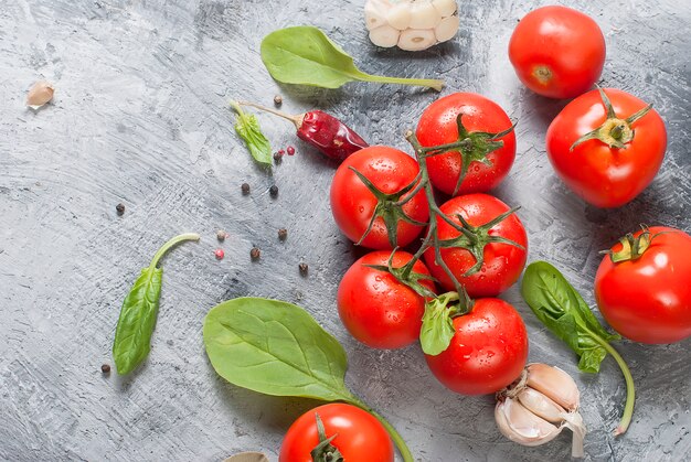 Cherry tomatoes on a branch, spinach leaves and spice