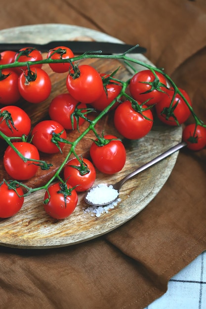 Cherry tomatoes on a branch on a wooden tray