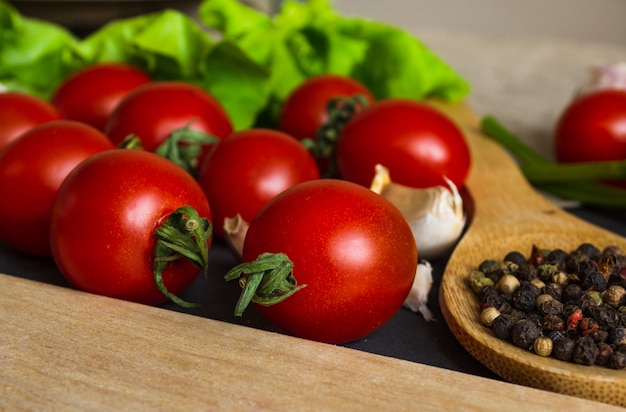 Cherry tomatoes closeup. Tomatoes, spices, garlic and lettuce on the table