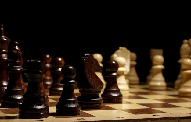 Chess board with chess pieces isolated on black