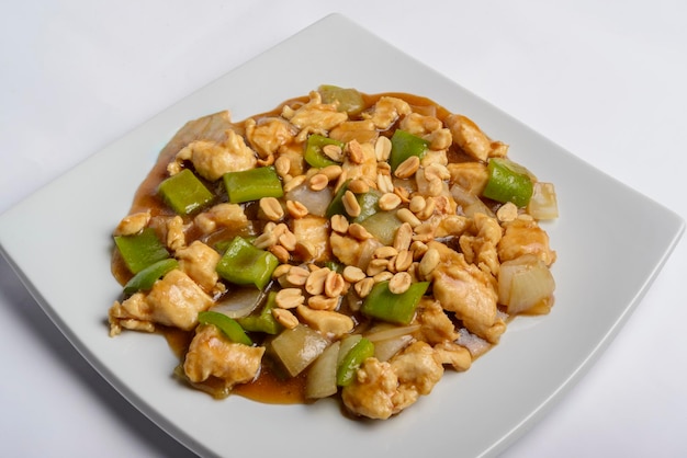 Chess chicken with green peppers onions and peanuts in white plate isolated Chinese traditional food