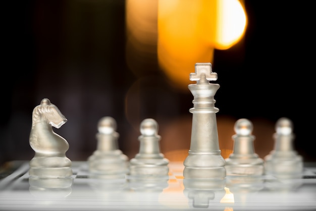 Chess king staying before the set of another with bokeh light background. 