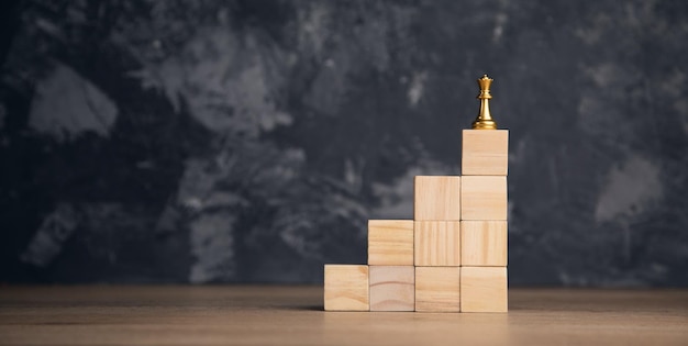 Chess on the wooden cube on abstract background