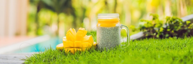 Chia seed pudding with almond milk and fresh mango topping on the background of the pool banner long