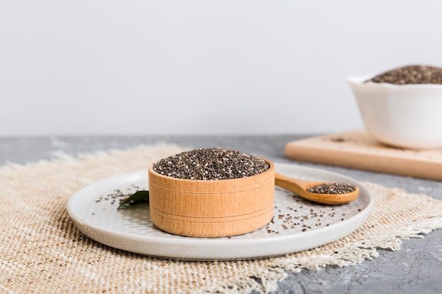 Chia seeds in bowl and spoon on colored background Healthy Salvia hispanica in small bowl Healthy superfood