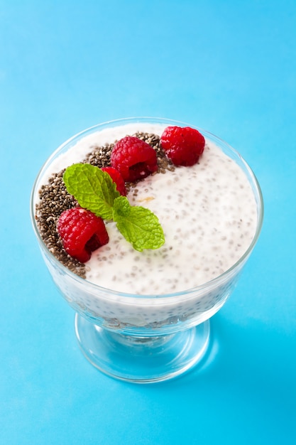 Chia yogurt with raspberries on blue