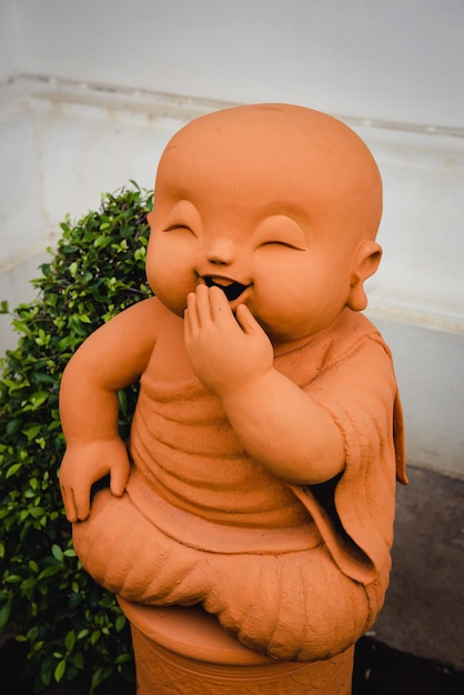 Photo chiang mai, thailand - june 10, 2016: laughing statue of monk made of clay as a decor on the streets of chiang mai