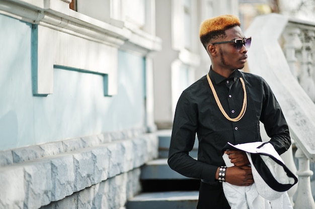 Chic handsome man in shirt with gold chain and sunglasses.