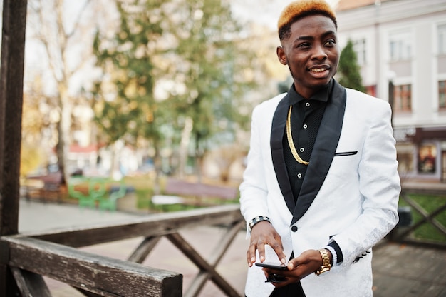 Chic handsome man in white suit with mobile phone at hand.