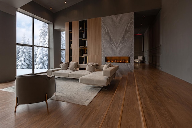 Chic modern design of a dark expensive interior of a luxurious country house with huge panoramic windows and a magnificent view of the divine forest