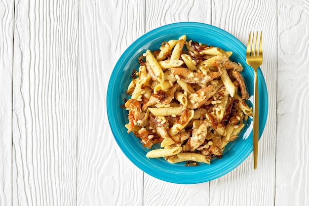 Photo chicken alfredo pasta penne with caramelized onion