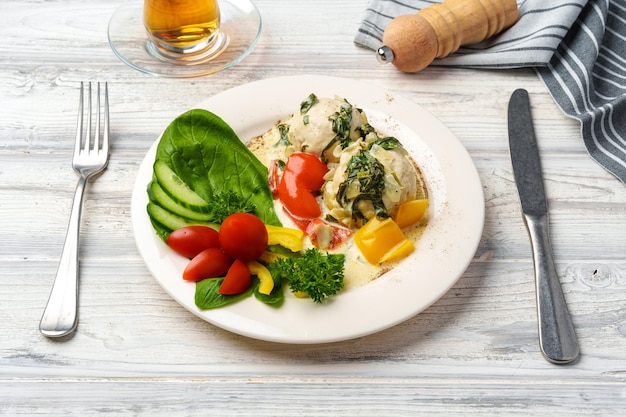 Chicken breast cooked in sauce and fresh vegetables served on plate in cafe