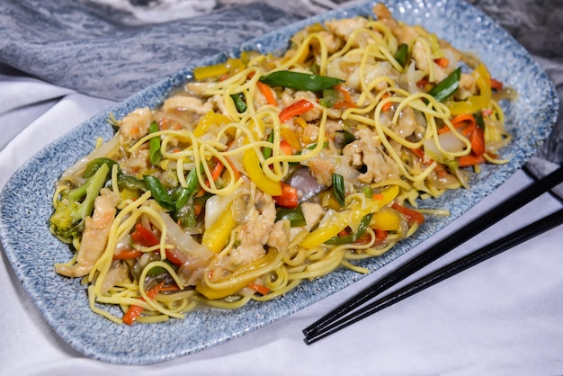 Photo chicken chowmein and vegetable chow mein and chopsticks served in dish isolated on food table top view of middle east spices