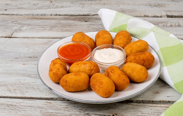 Chicken croquettes with tomato mayonnaise sauces served on a plate