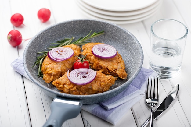 Chicken cutlets baked in corn flakes in a pan